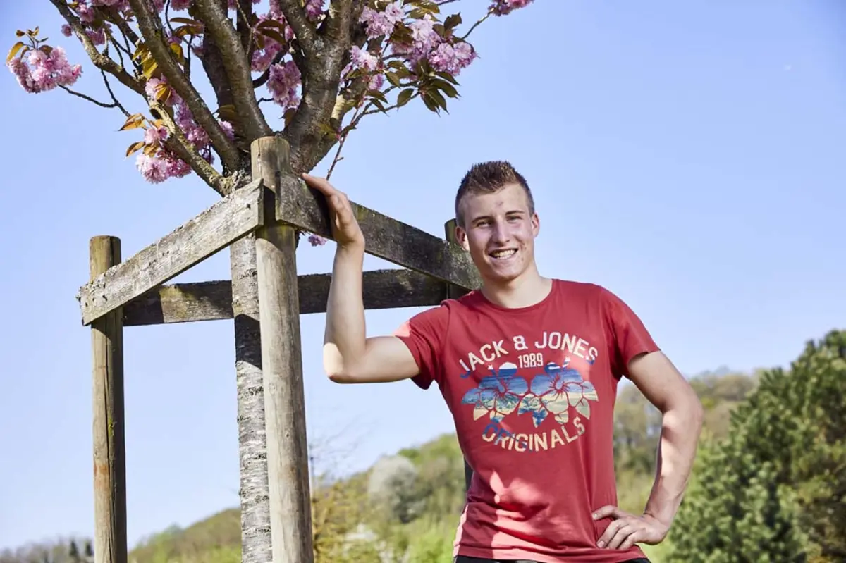 Florent prend la pose devant un arbre fruitier
