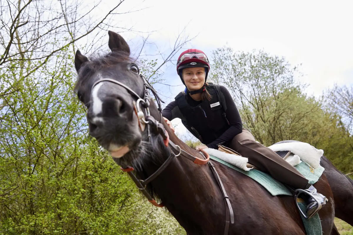 Vue en contre plong&eacute;e d'une jeune cavali&egrave;re sur son cheval