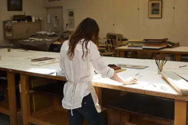 Anastasia de dos pose les mains sur son bureau d'encadrement