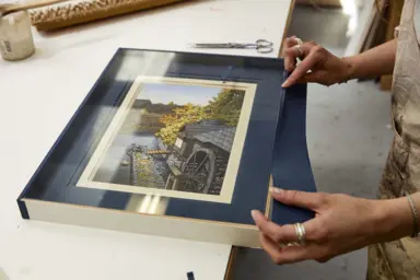 Deux mains tenant un cadre avec une photo &agrave; l'int&eacute;rieur