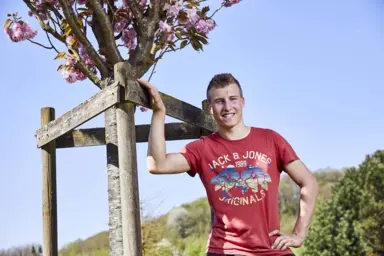 Florent prend la pose devant un arbre fruitier