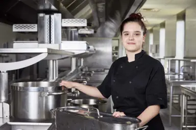 Lola pose dans une cuisine professionnelle
